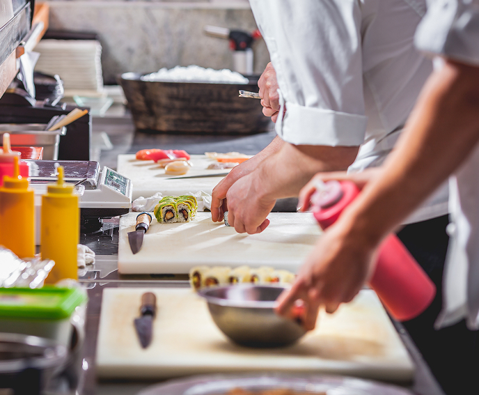 Chefs prepping a plate in a kitchen