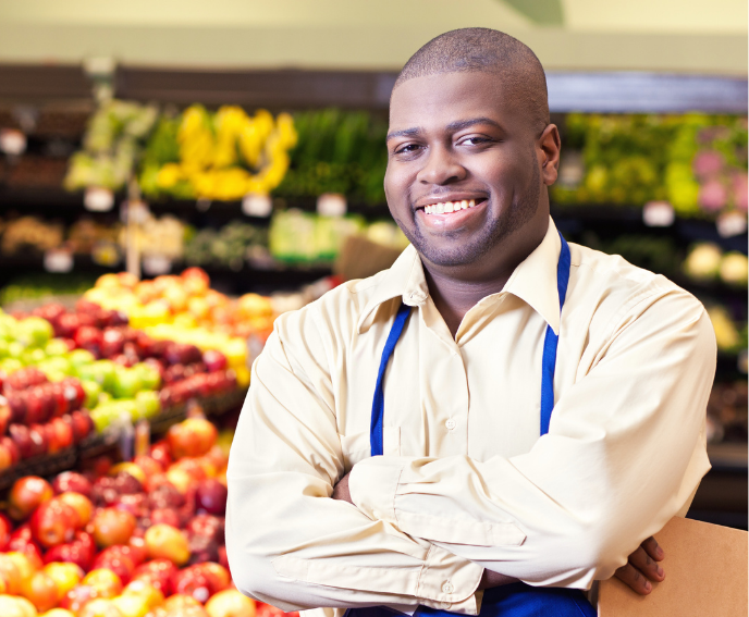 male grocery store employee in front of the produce section