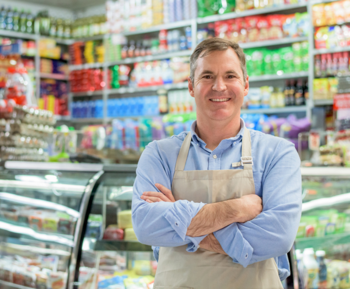 male grocery store employee in front of shelves of inventory